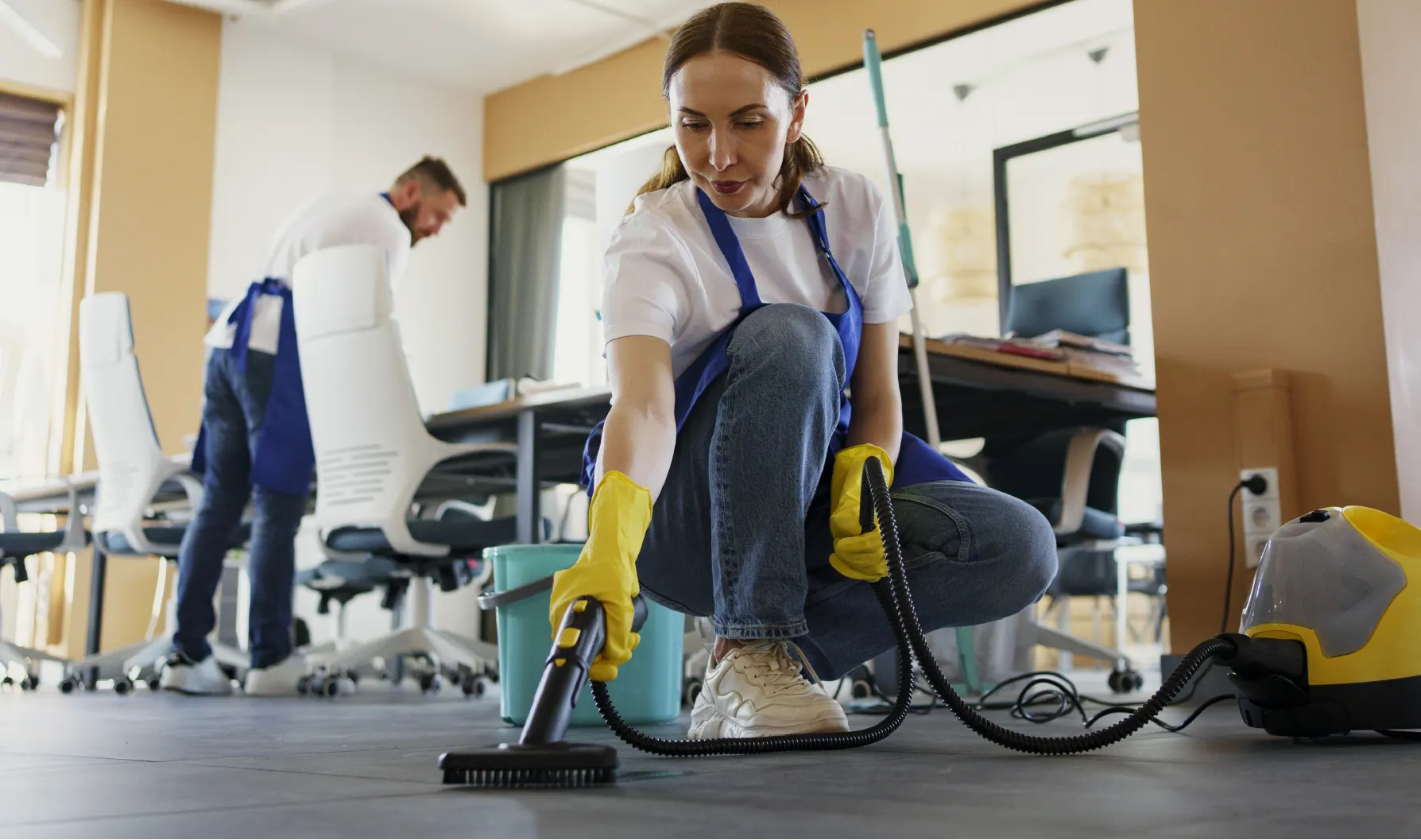 Cleaner vacuuming office floor